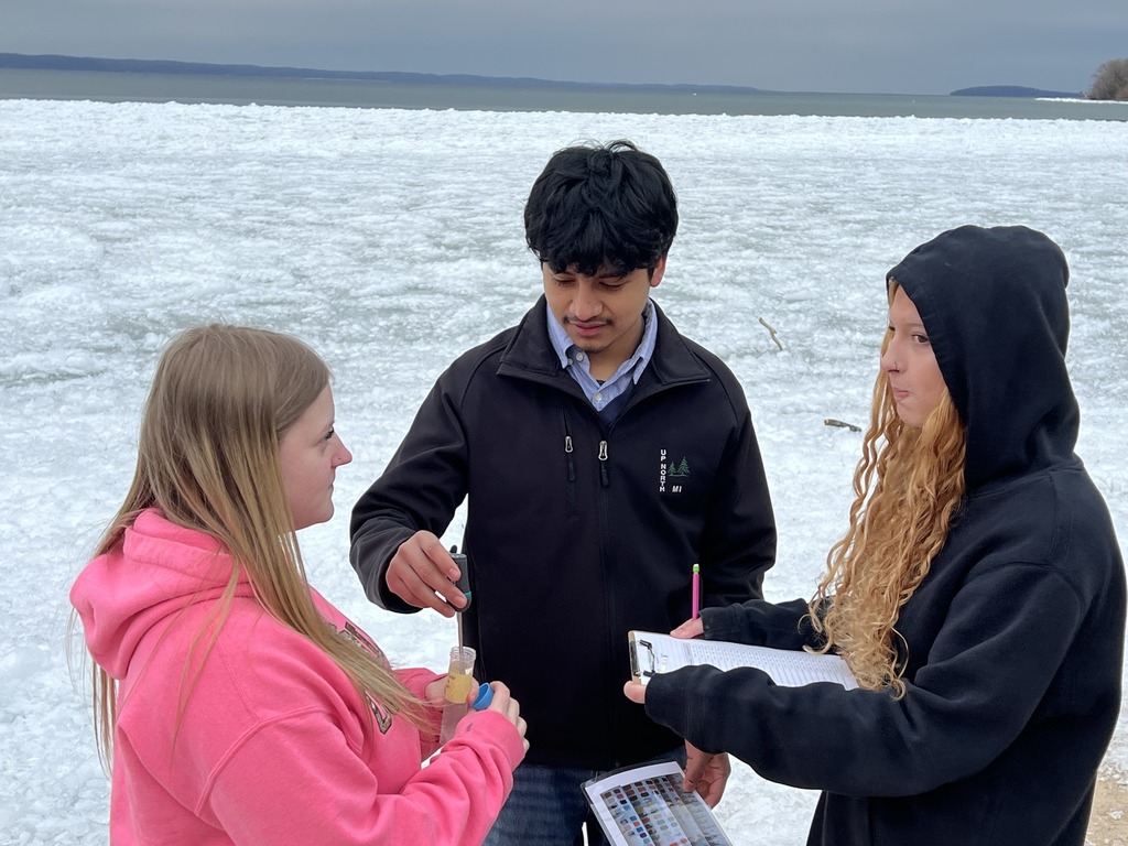 Students standing at the bayshore, exchanging data.
