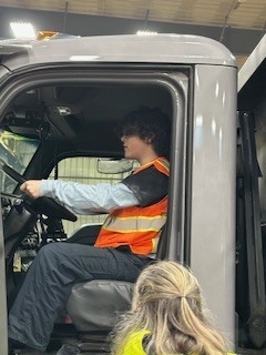 TCHS student toured Elmer's and is pictured sitting in the driver's seat of an Elmer's truck
