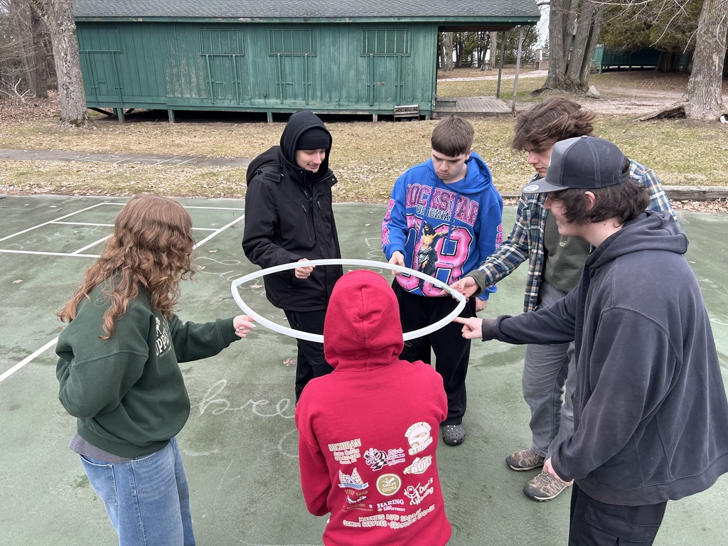 TCHS graduates participate in a hula hoop team building activity outside Camp LOC