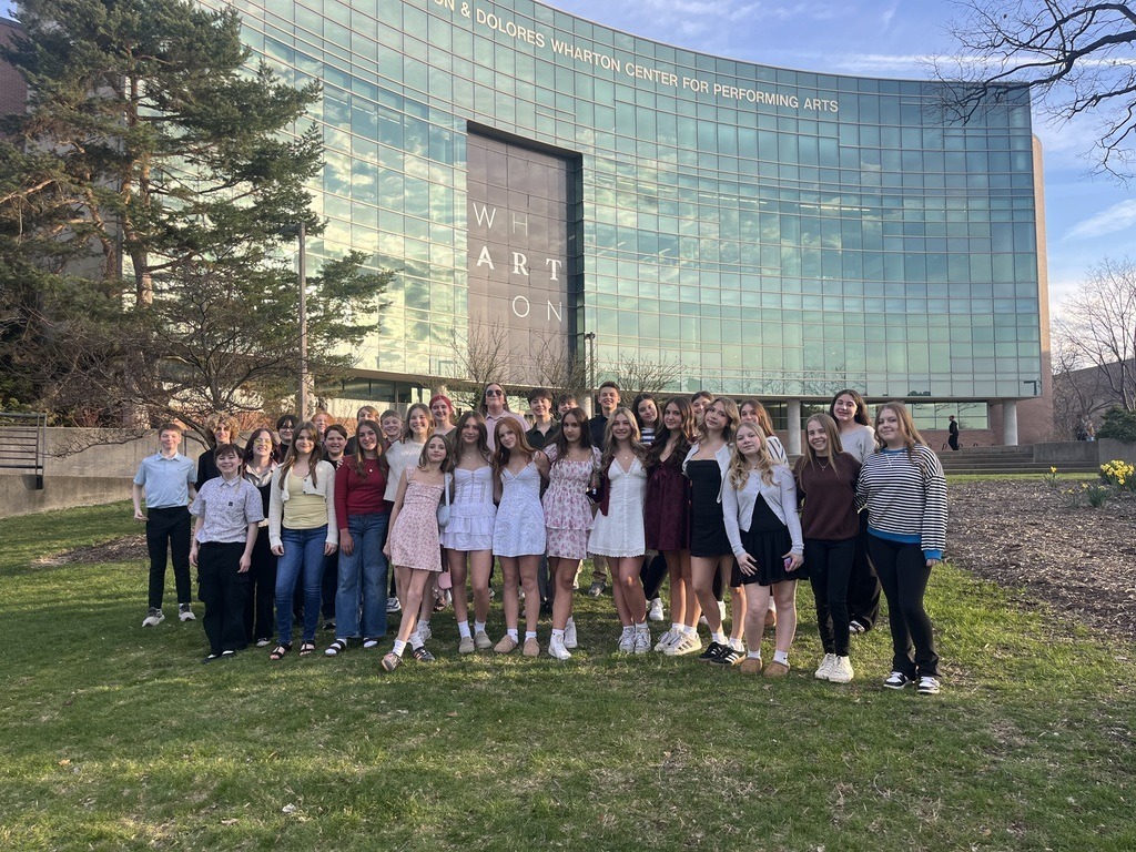 Students from the Chamber Choir standing in front of the Wharton Center for Performing Arts building.