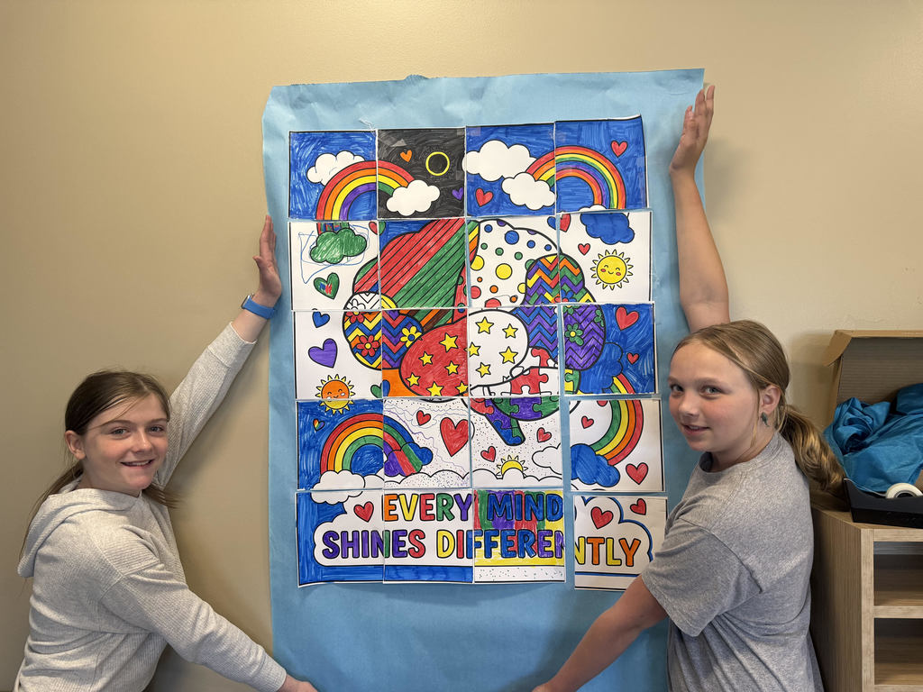 Students holding up a poster that says Every Mind Shines Differently.