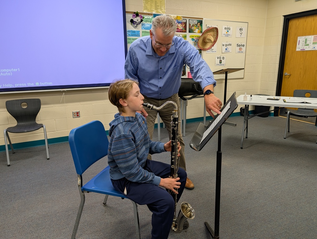 An 8th grade bass clarinet player receives feedback on their performance from Mr. Lampman.