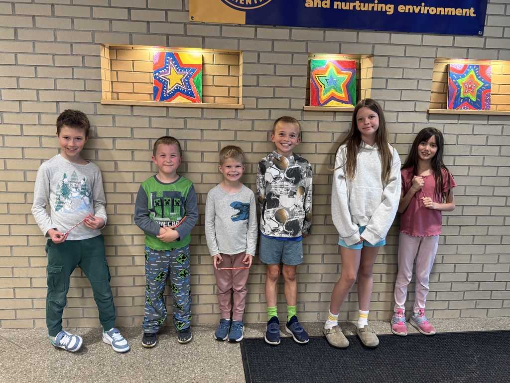 Six Eastern Elementary students, 4 boys and two girls, standing against a lobby brick wall with star paintings in the background.