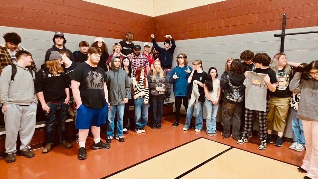 A group of students stands on a gym floor.
