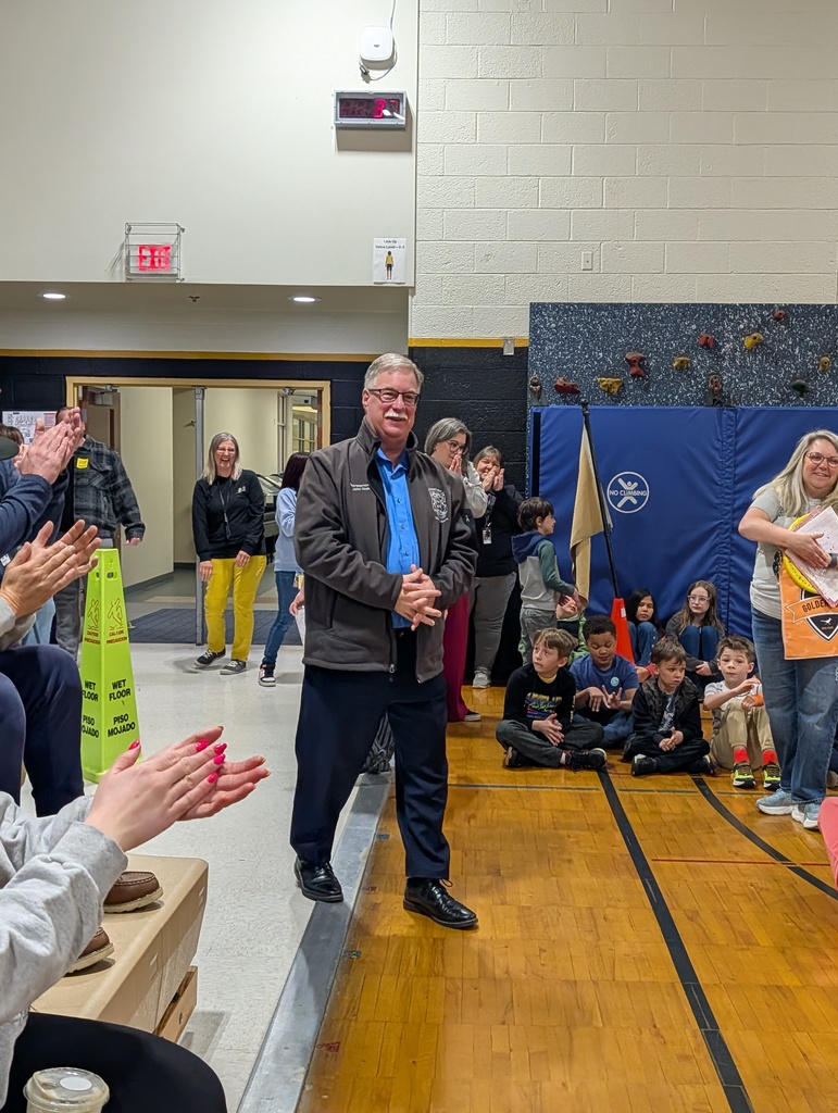 Michigan State Representative John Roth in a gymnasium with others clapping.