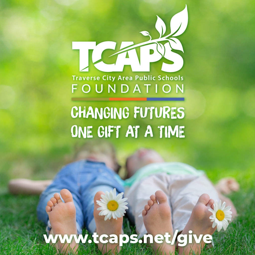 Two children lie on grass with daisies. "TCAPS FOUNDATION" and "CHANGING FUTURES ONE GIFT AT A TIME" text. Website address: www.tcaps.net/give.