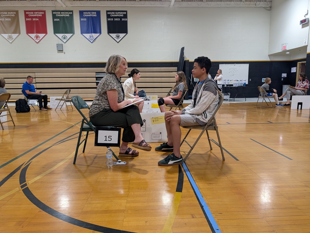 Student interviews with community member in gym for Amazing shake event