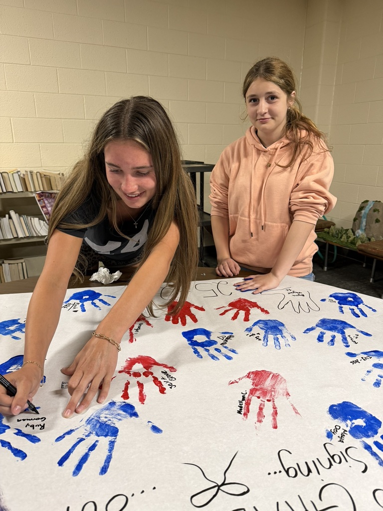 8th grade choir making their hand painted poster.