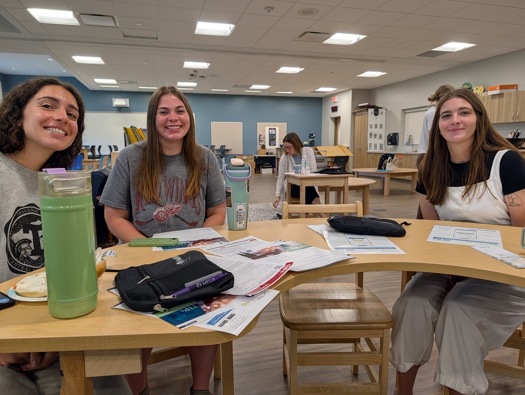 Staff members smiling for pictures at new teacher orientation. 
