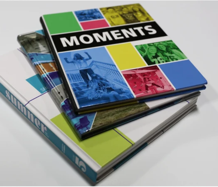 Stack of three colorful yearbooks
