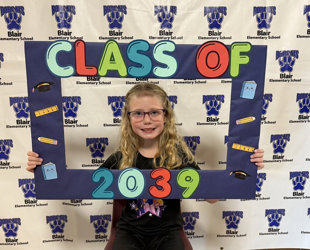 Kindergarten student holding a "class of 2039" sign.