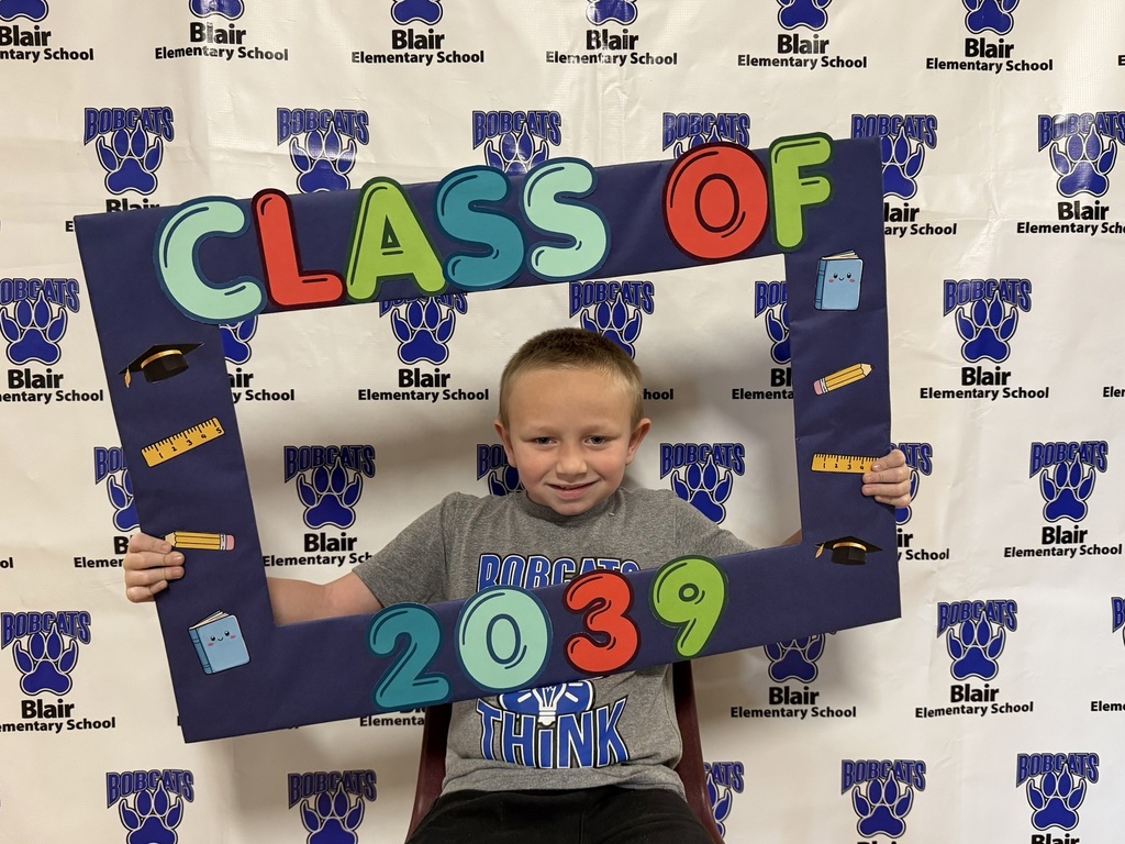 Kindergarten student holding a "class of 2039" sign.