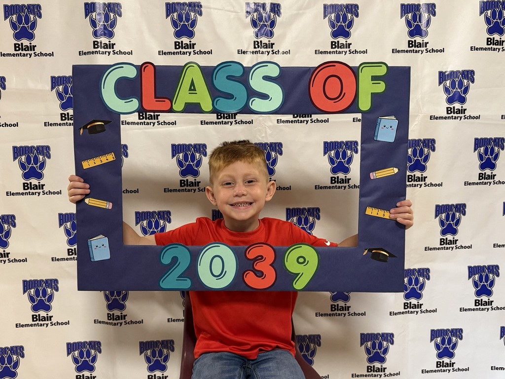 Kindergarten student holding a "class of 2039" sign.