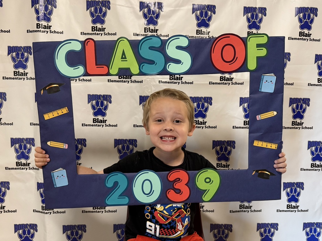 Kindergarten student holding a "class of 2039" sign.