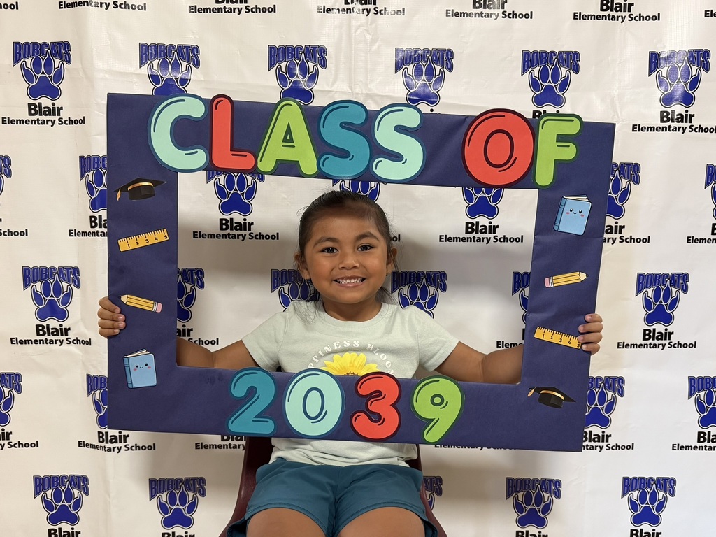 Kindergarten student holding a "class of 2039" sign.