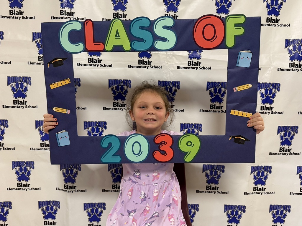 Kindergarten student holding a "class of 2039" sign.