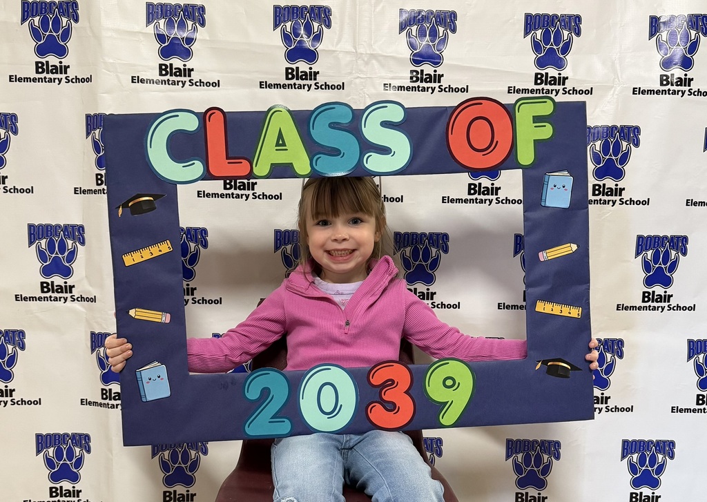 Kindergarten student holding a "class of 2039" sign.