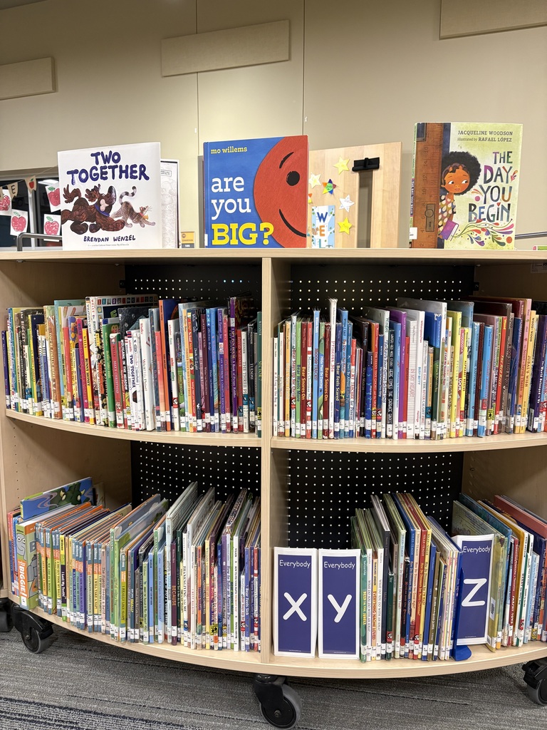 Circular book display with multiple shelves, each labeled with letters X, Y, Z. Books of various sizes and colors on shelves.