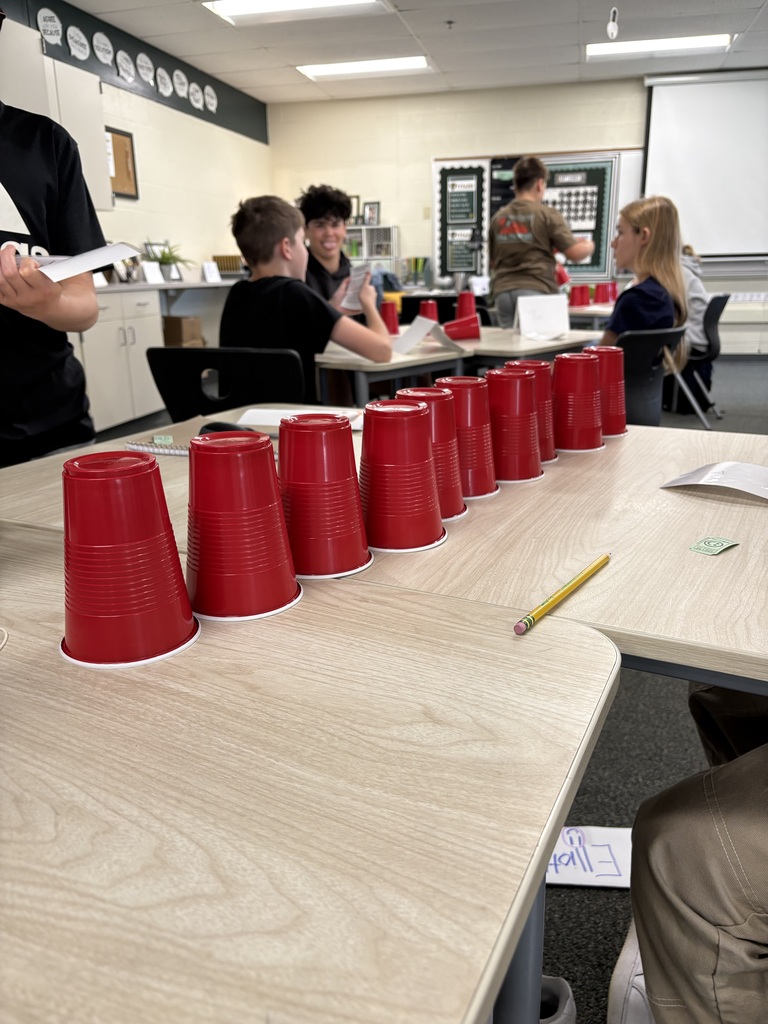 Line of 10 red Solo cups in a row on a desk