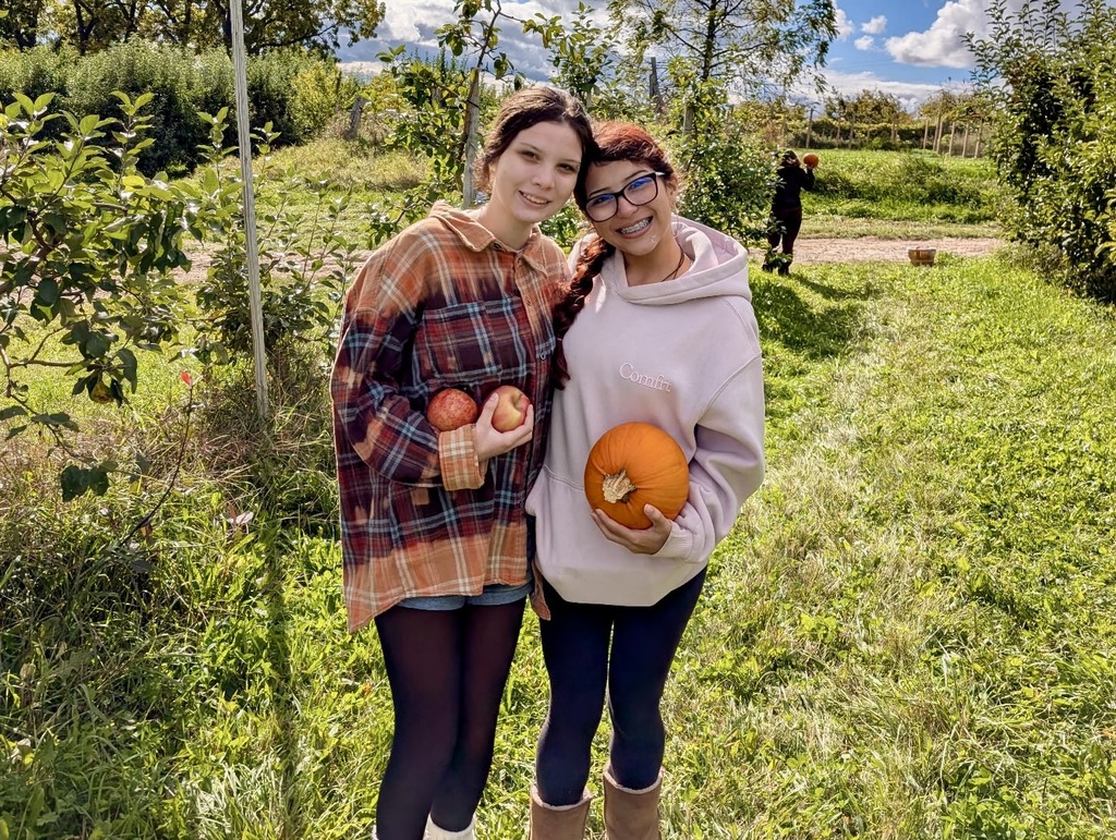 TCHS students hold pumpkins an orchard at Rennie Orchards