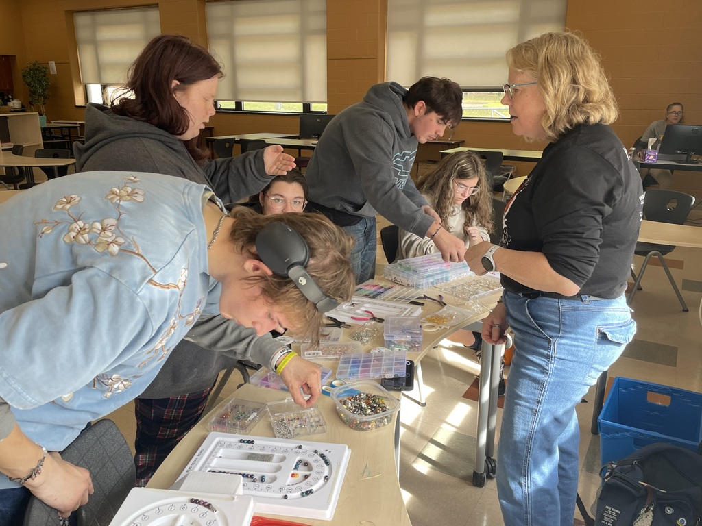 TCHS students create jewelry with a TADL volunteer