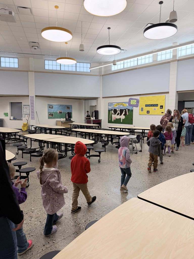Preschool students walking through the elementary cafeteria into the servery.