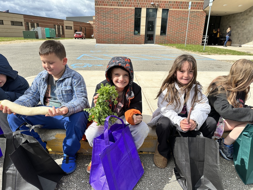 Students showing off there fresh vegetables from the school farmers market.