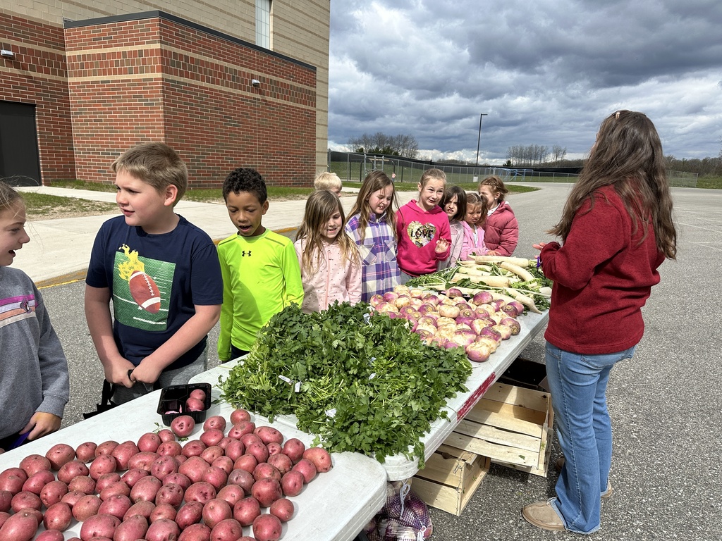 Students pick out vegetable at the TCE farmers market.