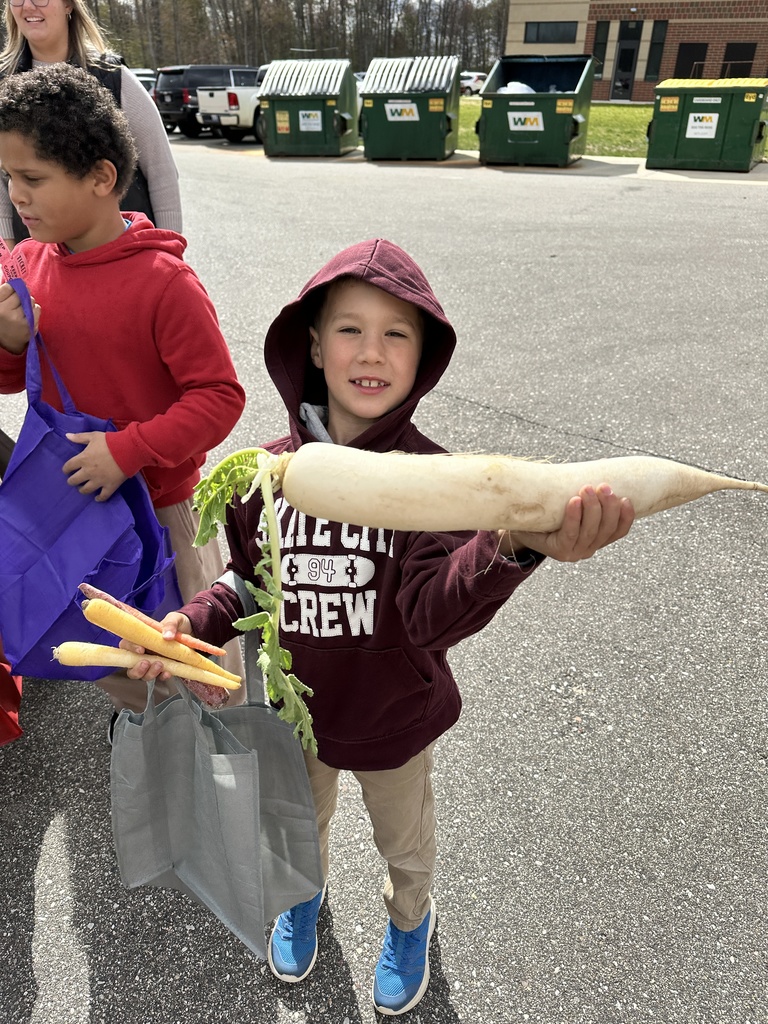 A student shows off there fresh vegetables from the school farmers market