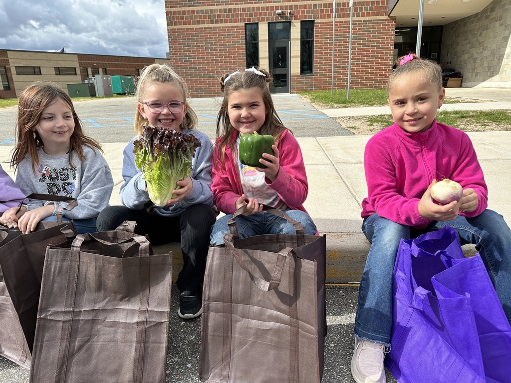 Students showing off there fresh vegetables from the school farmers market.
