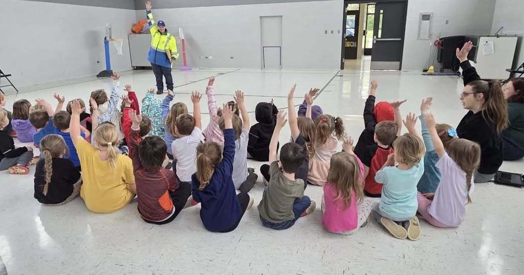 Preschool students listen to a story about a garbage truck.