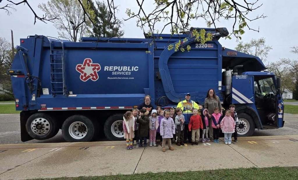 Preschool students in front of a garbage truck after hearing a story and learning about waste services.