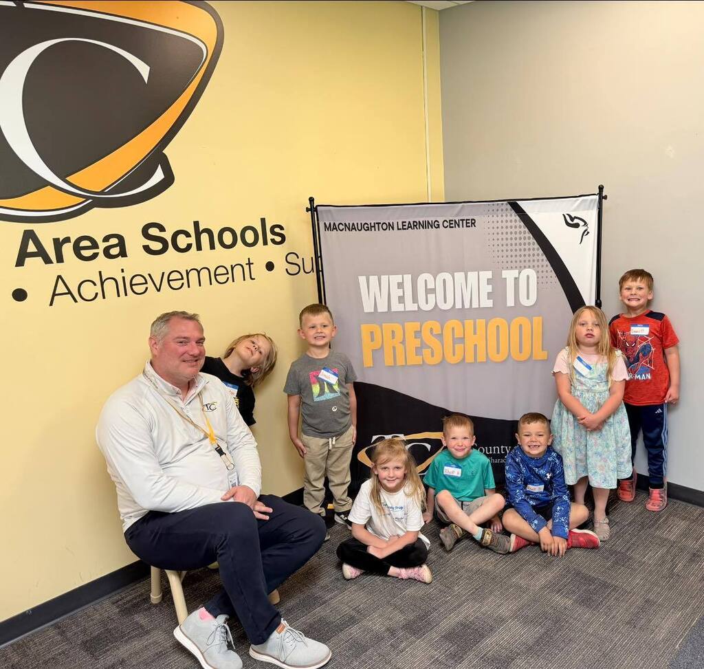 Mr Biller, the Superintendent, posing with preschool students.