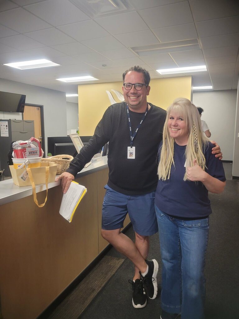 Mr. Schultz posing with a Wesco employees after winning a gift basket.