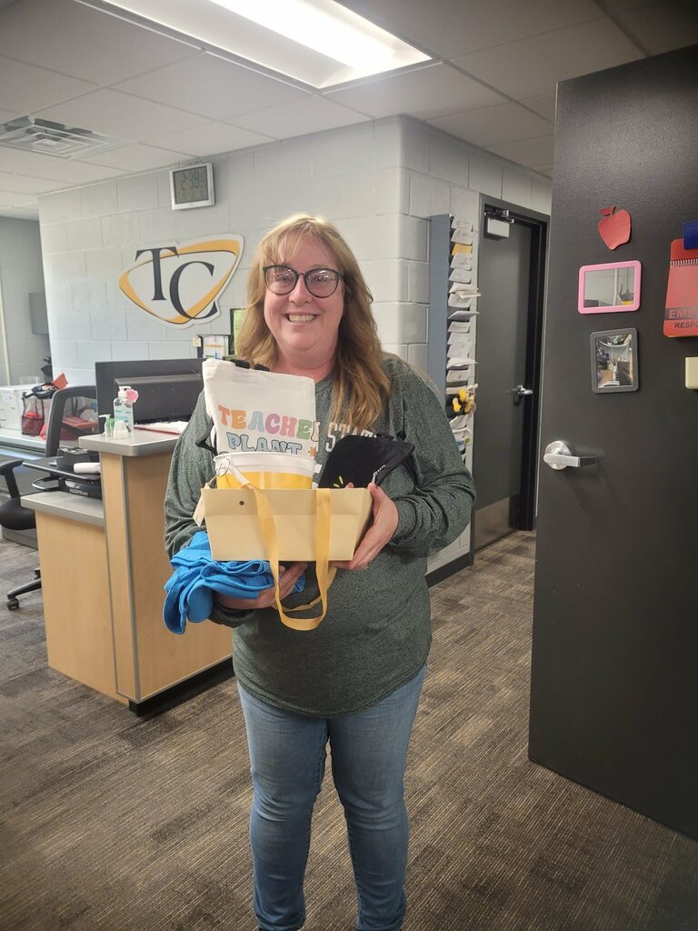 Mrs. Helter posing with a Wesco employees after winning a gift basket.