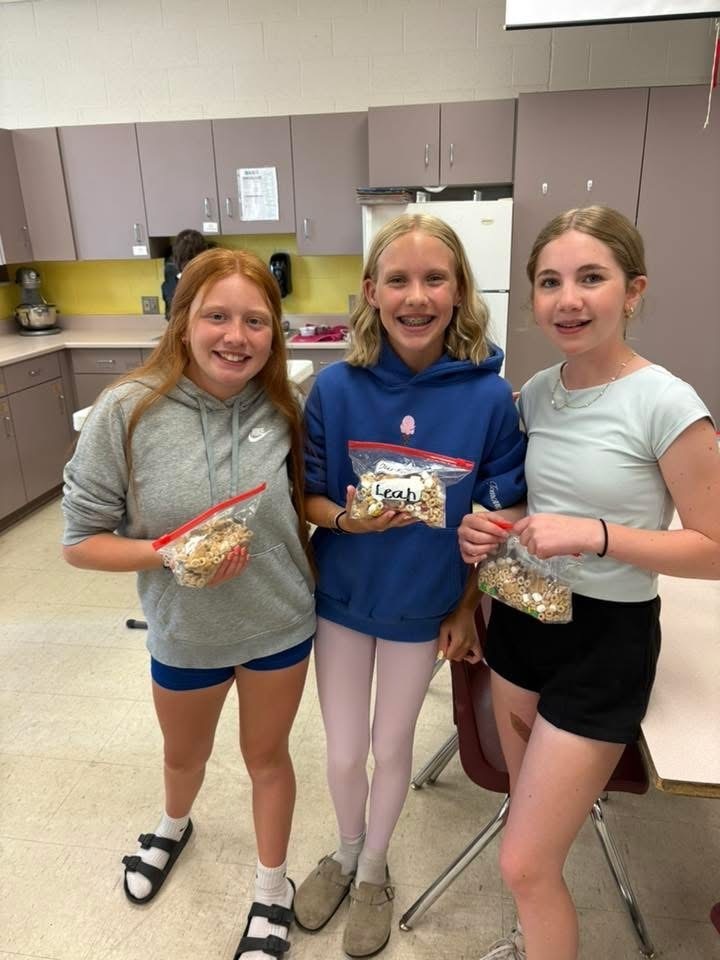 Three students with trail mix made in Culinary School. 