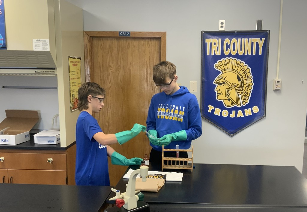 Students using PPE and lab safety technique during biology lab. 