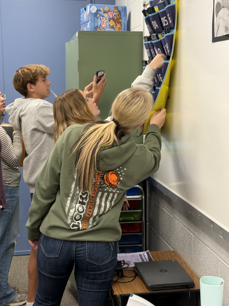 Students look for the key behind the calculator holder.