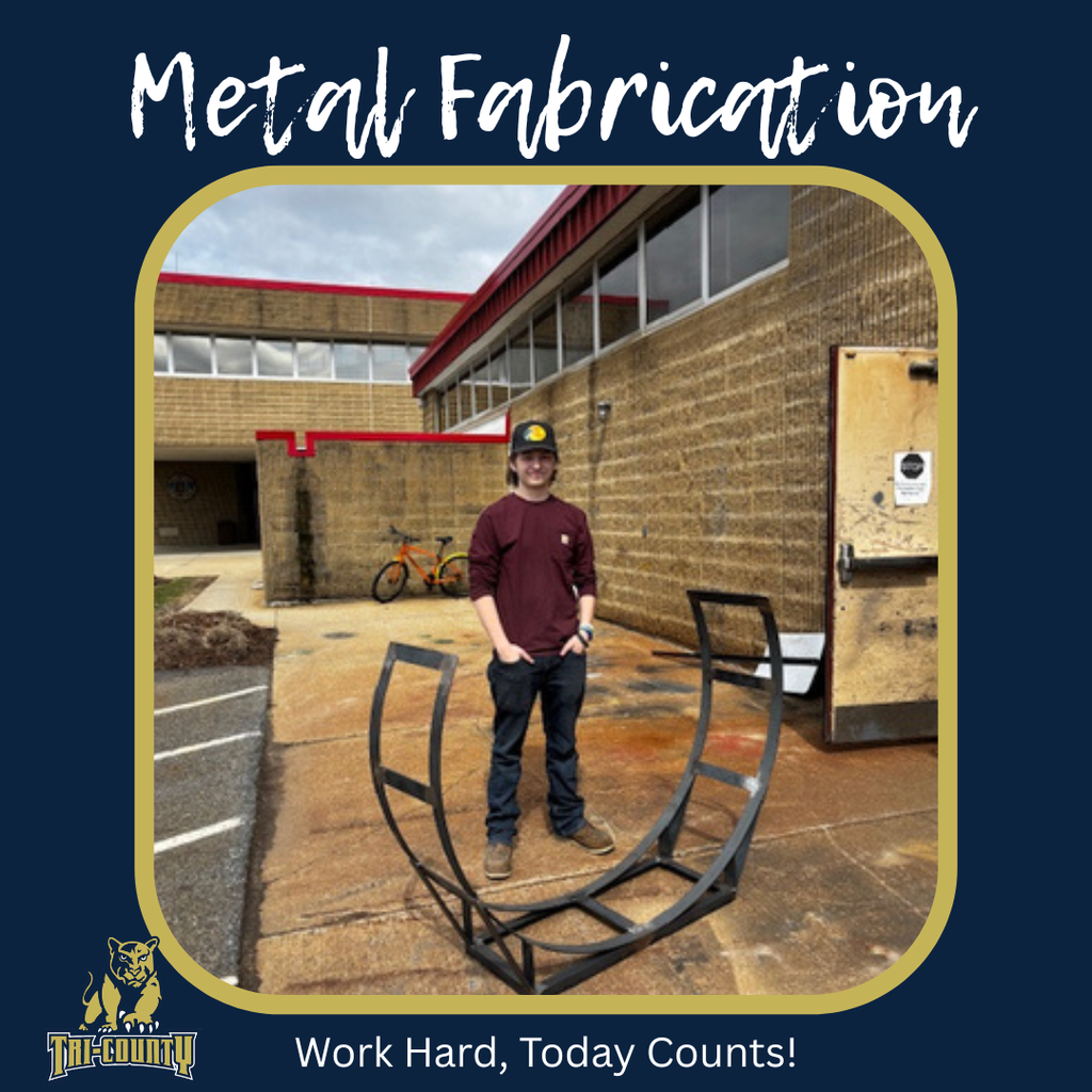 Metal Fabrication student standing with the firewood holder he built.