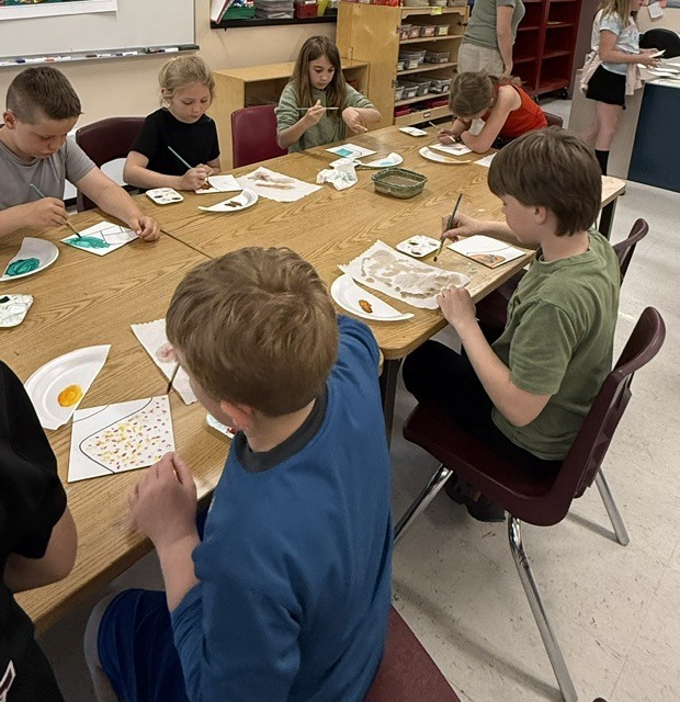 Students painting tiles.