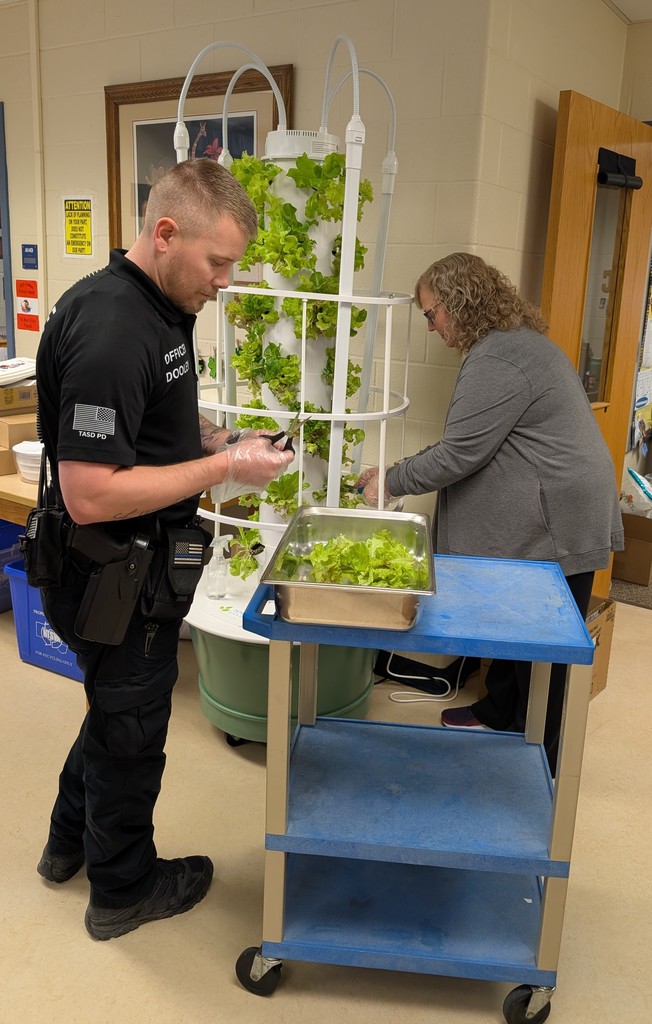 Officer Dooley and Mrs. Curren cutting off the lettuce