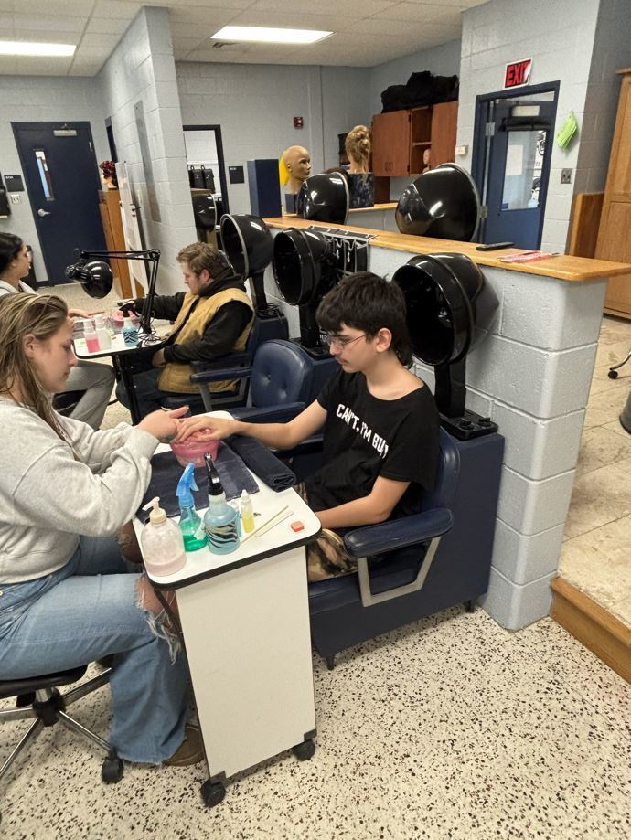two students receiving manicures