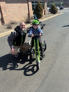 Student on adaptive bike with principal