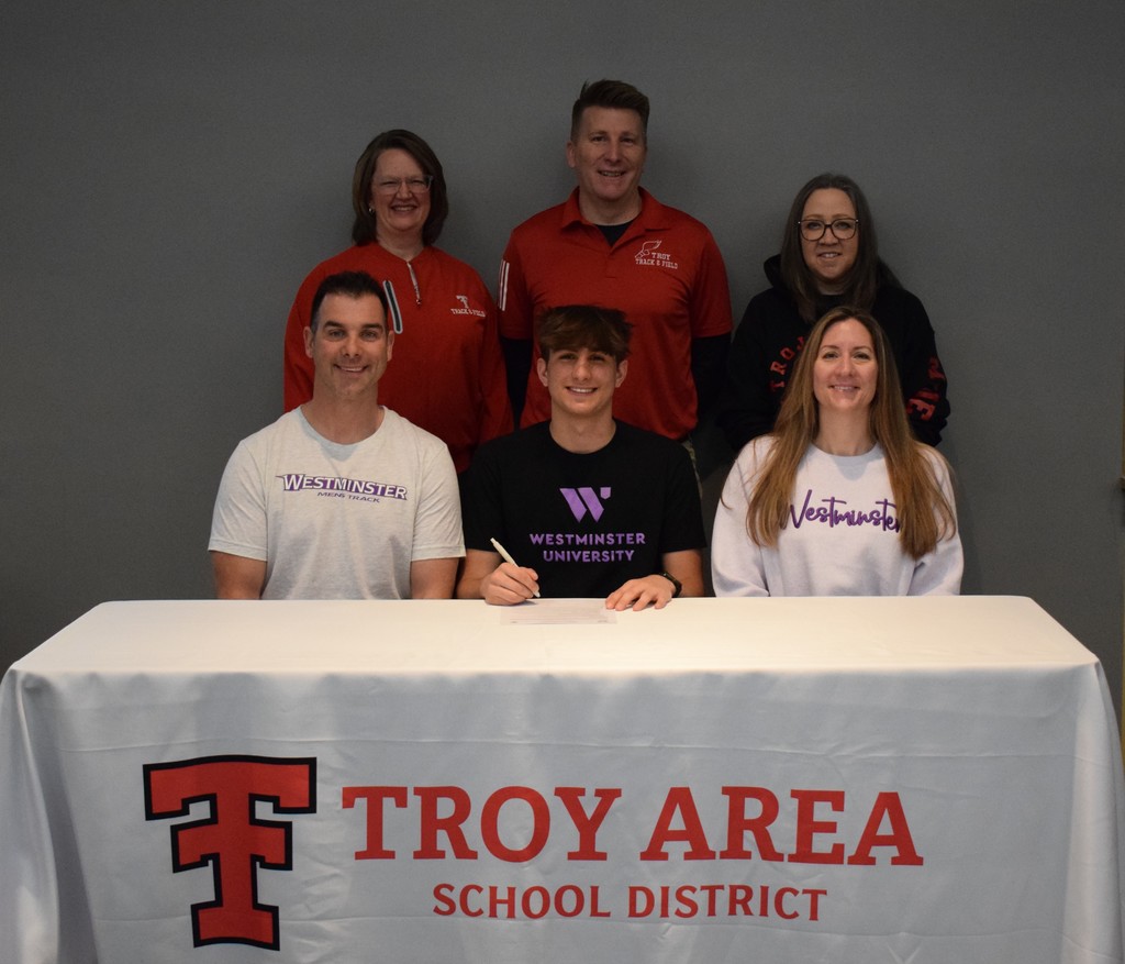 student, parents and coaches for college signing