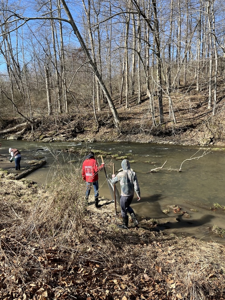 photo of students two of them walking next to a stream