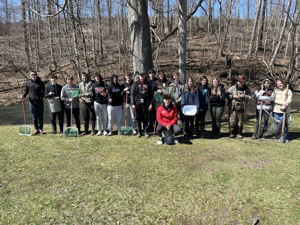Photo of students in front of a steam with nets and wading boots