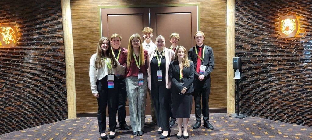 8 students standing in front of a hotel lobby before they head into state competitions for FBLA