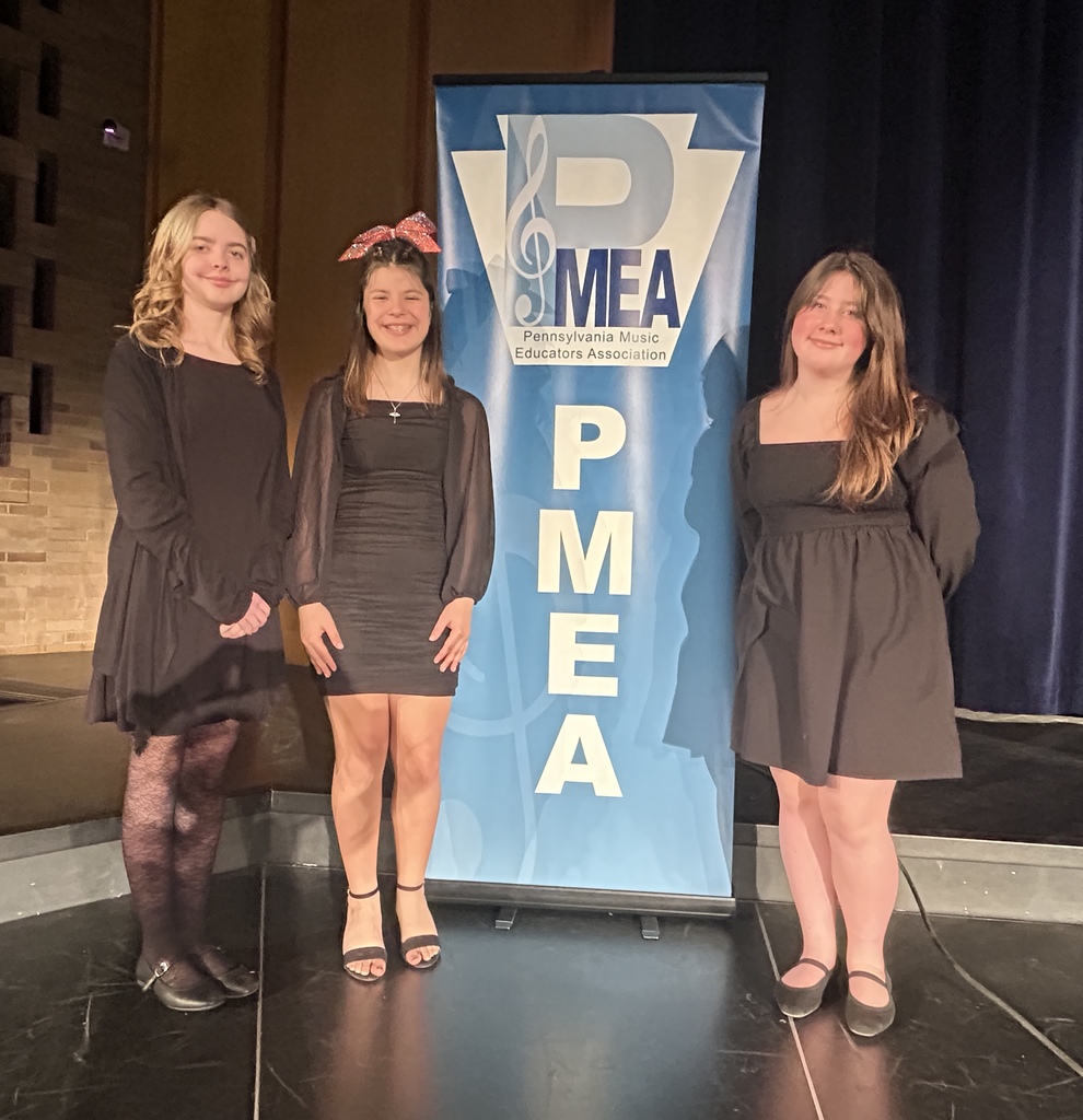 3 students in front of the PMEA Jazz sign with instruments and smiles