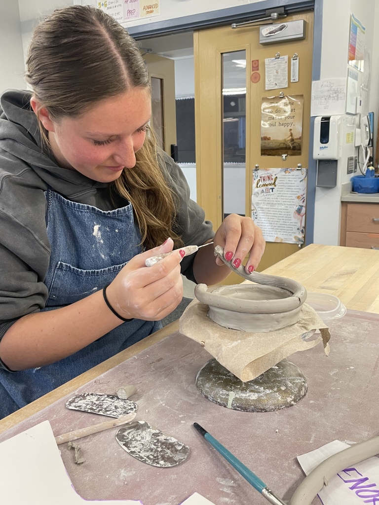 Student working with clay tools