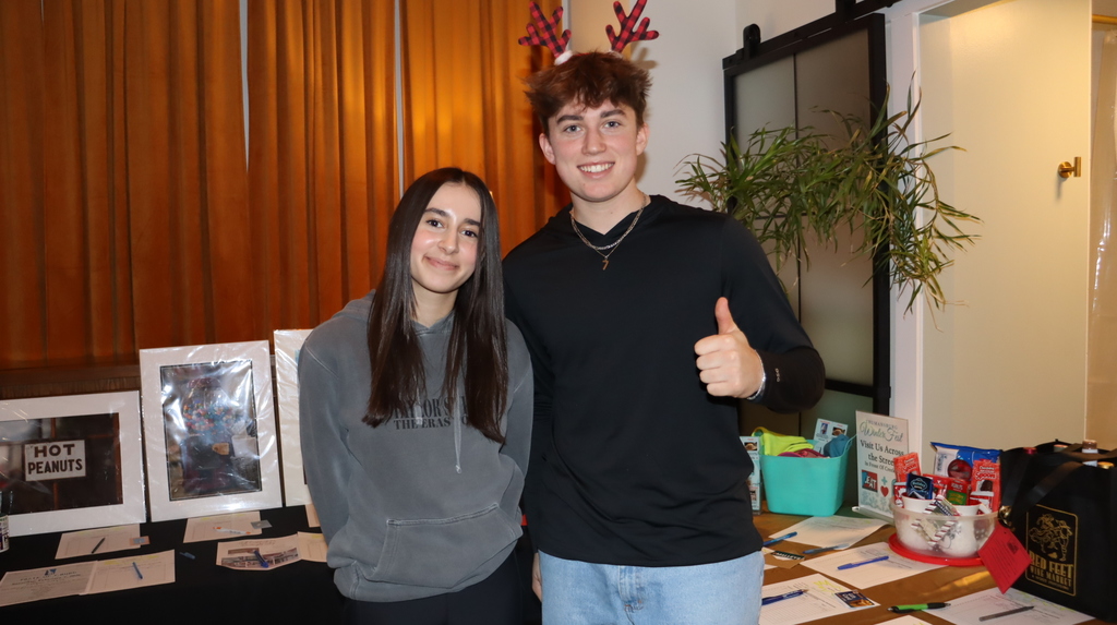 Students posing with a various prizes table
